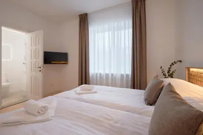 a bedroom with a large white bed with towels on it at Jonavos alpakų svečių namai in Jonava