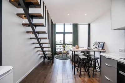 a kitchen and dining room with a staircase and a table at Modern Loft Walk to Center Fast Wi-Fi in Vilnius