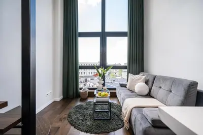 a living room with a couch and a large window at Modern Loft Walk to Center Fast Wi-Fi in Vilnius