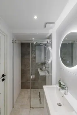 a white bathroom with a shower and a sink at Modern Loft Walk to Center Fast Wi-Fi in Vilnius