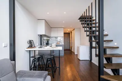 a kitchen and living room with a spiral staircase in a house at Modern Loft Walk to Center Fast Wi-Fi in Vilnius