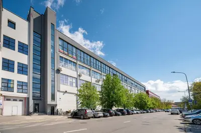 a large building with cars parked in a parking lot at Modern Loft Walk to Center Fast Wi-Fi in Vilnius