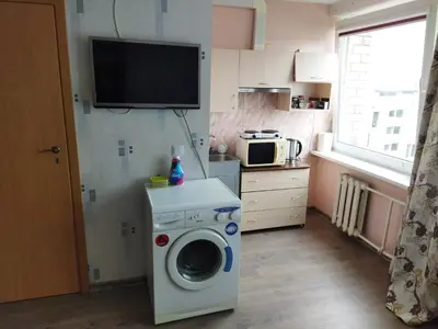 a kitchen with a washing machine and a tv at Itaja apartment 50 in Šiauliai