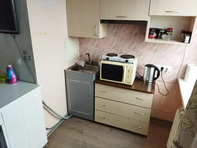 a small kitchen with a microwave and a sink at Itaja apartment 50 in Šiauliai