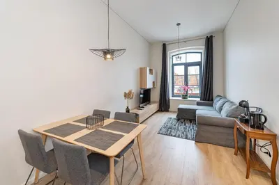 a living room with a table and a couch at Shanti barracks apartment by Polo Apartments in Kaunas