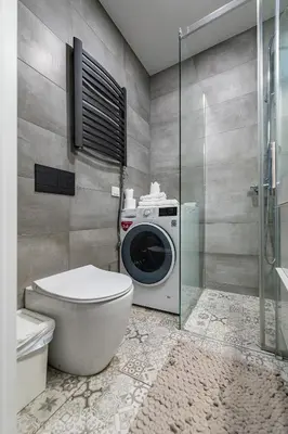 a bathroom with a washing machine and a toilet at Shanti barracks apartment by Polo Apartments in Kaunas