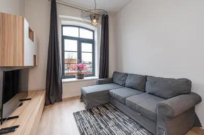 a living room with a couch and a window at Shanti barracks apartment by Polo Apartments in Kaunas