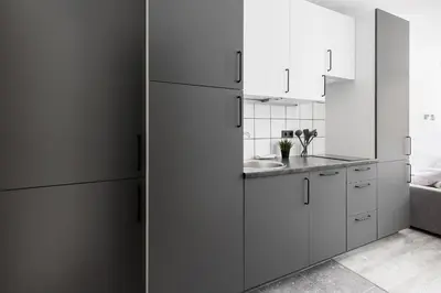 a kitchen with white cabinets and a refrigerator at River To The City - Self check in in Vilnius