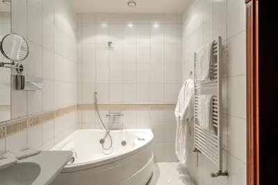 a white bathroom with a tub and a sink at Hotel Sfinksas in Kaunas