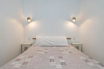 a bed in a room with two lights on the wall at Sophisticated Old town apartment by Polo Apartments in Kaunas