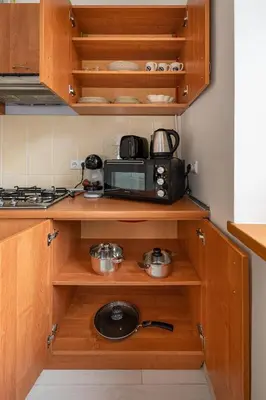 a kitchen with wooden cabinets and a microwave at Sophisticated Old town apartment by Polo Apartments in Kaunas