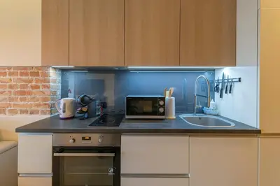 a kitchen with a counter with a microwave and a sink at Deluxe river view apartment by Polo Apartment in Kaunas