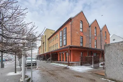a red brick building with a car parked in front of it at Deluxe river view apartment by Polo Apartment in Kaunas