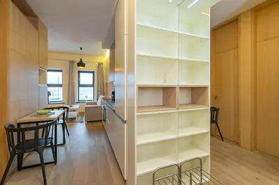 a kitchen and dining room with white shelves and a table at Deluxe river view apartment by Polo Apartment in Kaunas