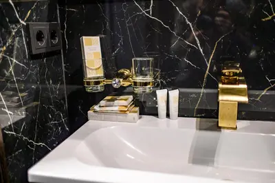 a bathroom with a sink and a glass of whiskey at Diamond svečių namai in Kaunas
