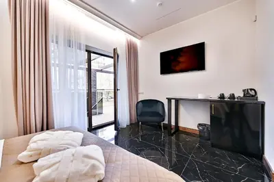 a bedroom with a bed and a desk and a television at Diamond svečių namai in Kaunas