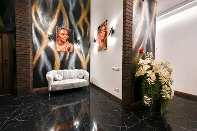 a living room with a chair and a wall with paintings at Diamond svečių namai in Kaunas