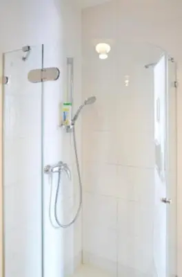 a bathroom with a shower with a glass door at Bright apartment in Old Town by URBAN RENT in Vilnius
