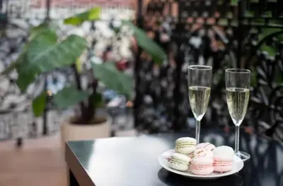 two glasses of champagne and some macaroons on a table at Bright apartment in Old Town by URBAN RENT in Vilnius