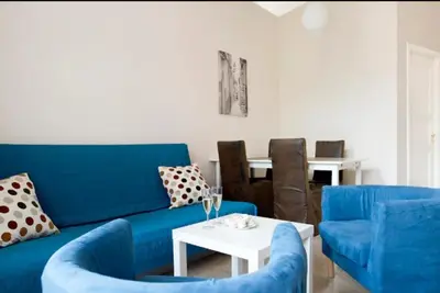 a living room with a blue couch and chairs at Bright apartment in Old Town by URBAN RENT in Vilnius