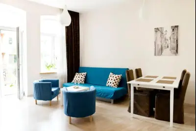 a living room with a blue couch and a table at Bright apartment in Old Town by URBAN RENT in Vilnius