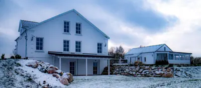 a white house with snow on the ground at Bebryno slėnis in Staškūniškis