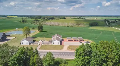 an aerial view of a house in a green field at Bebryno slėnis in Staškūniškis