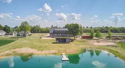 an aerial view of a house with a pond at Bebryno slėnis in Staškūniškis