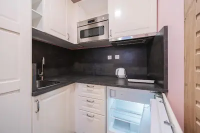 a kitchen with white cabinets and a microwave at Station Self Check-in Apartments - Lollo Stay in Vilnius