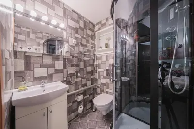 a bathroom with a toilet and a sink and a shower at Station Self Check-in Apartments - Lollo Stay in Vilnius