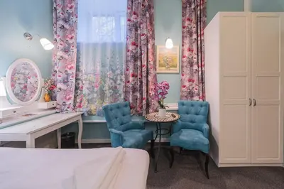 a bedroom with a desk and two blue chairs at Station Self Check-in Apartments - Lollo Stay in Vilnius