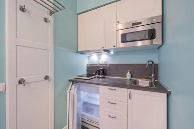 a small kitchen with white cabinets and a sink at Station Self Check-in Apartments - Lollo Stay in Vilnius