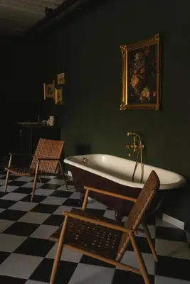 a bathroom with a bath tub and a chair at Aušrinės in Liškiava