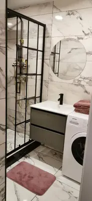 a bathroom with a sink and a washing machine at Apartaments in Šiauliai center in Šiauliai