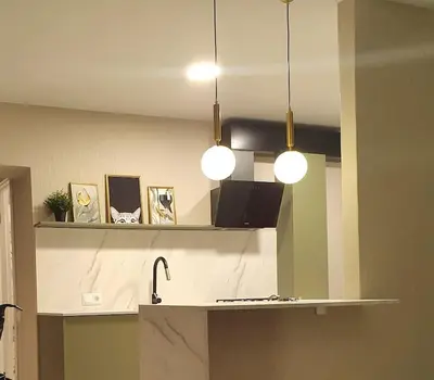 a kitchen with two pendant lights and a counter top at Apartaments in Šiauliai center in Šiauliai