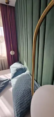 a bed sitting in a room with green walls at Apartaments in Šiauliai center in Šiauliai