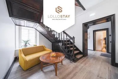 a living room with a couch and a stairway at Lollo Luxury Residence - Lollo Stay in Vilnius