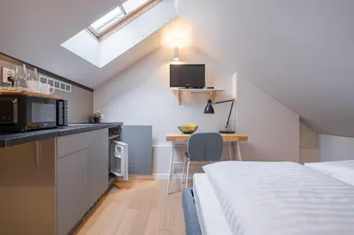 a room with a bed and a kitchen with a microwave at Lollo Luxury Residence - Lollo Stay in Vilnius