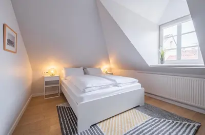 a white bedroom with a bed and a window at Lollo Luxury Residence - Lollo Stay in Vilnius