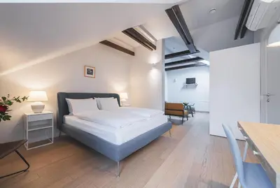 a bedroom with a bed and a dining table at Lollo Luxury Residence - Lollo Stay in Vilnius