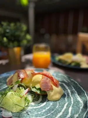 a plate with a sandwich and a glass of orange juice at CONTI HOTEL VILNIUS, Conference Centre, Restaurant & Bar in Vilnius