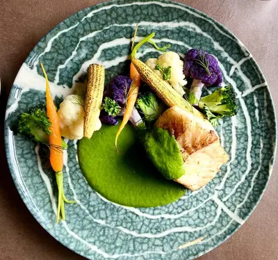 a plate of food with vegetables on a table at CONTI HOTEL VILNIUS, Conference Centre, Restaurant & Bar in Vilnius