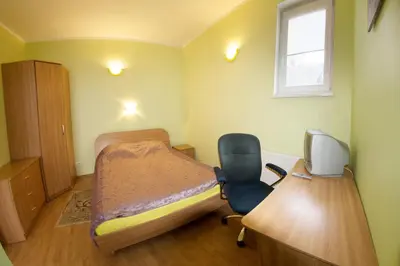 a bedroom with a desk and a bed and a chair at Laisves alley 50 in Kaunas