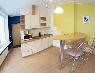 a kitchen with a table and chairs in a room at Laisves alley 50 in Kaunas