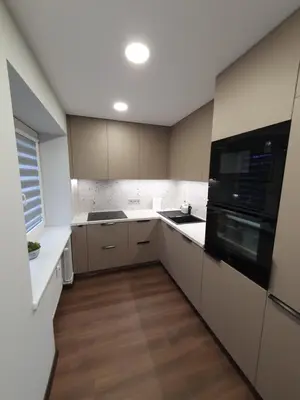 a kitchen with white cabinets and a black microwave at City apartment 2 bedrooms in Šiauliai