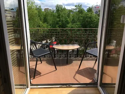 a patio with a table and chairs on a balcony at 4Work & Leisure I SELF-CHECKIN I 3PARKING I CENTRAL STATION DISTRICT - simpletone in Vilnius