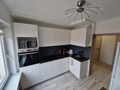 a kitchen with white cabinets and a ceiling at MilaAna in Visaginas