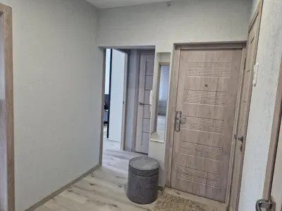 a hallway with two wooden doors and a stool at MilaAna in Visaginas