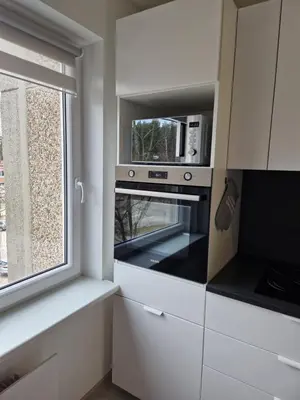 a kitchen with a microwave and a window at MilaAna in Visaginas