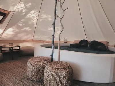a room with a bed in a tent with two logs at 